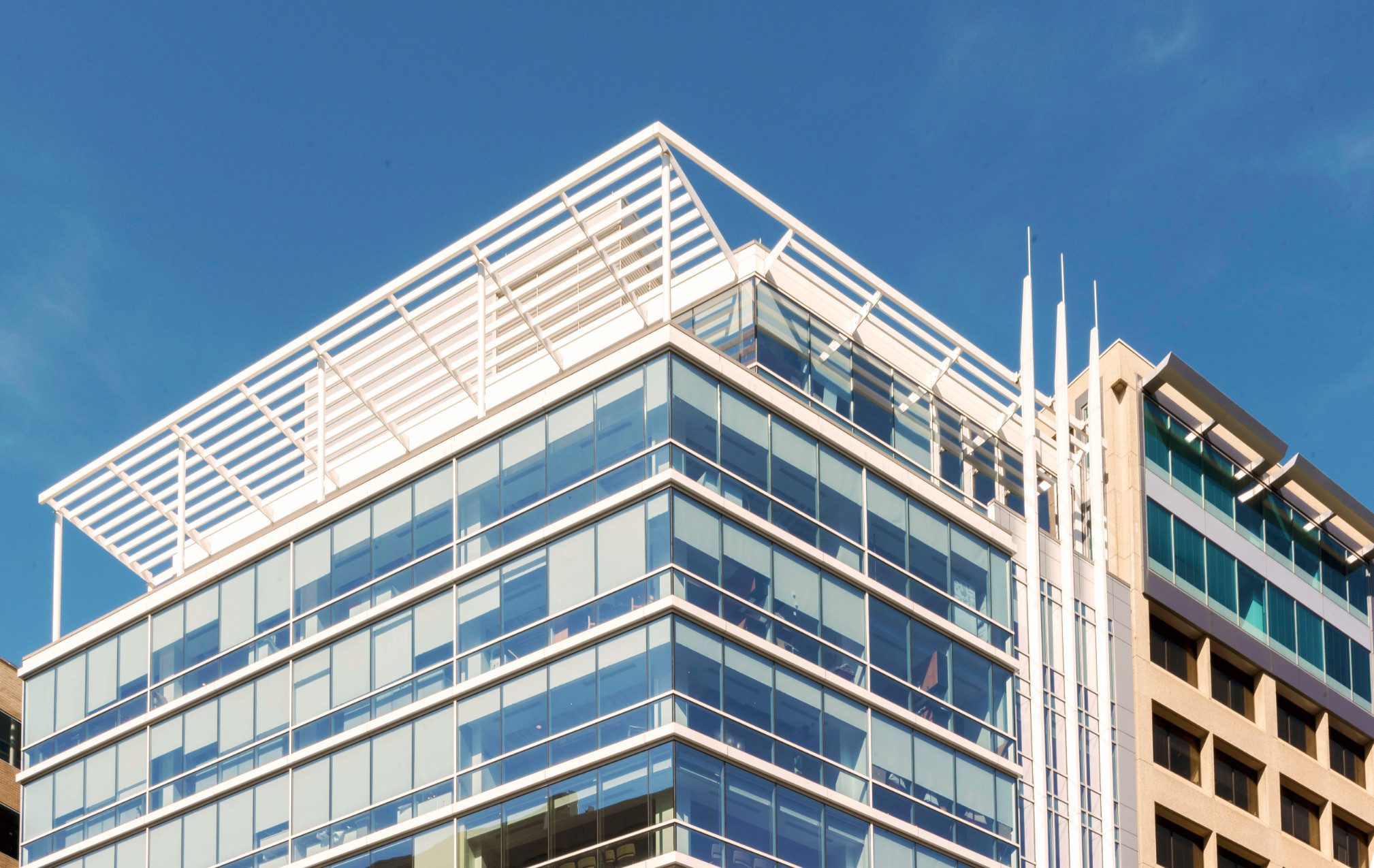 Modern glass building against clear blue sky.