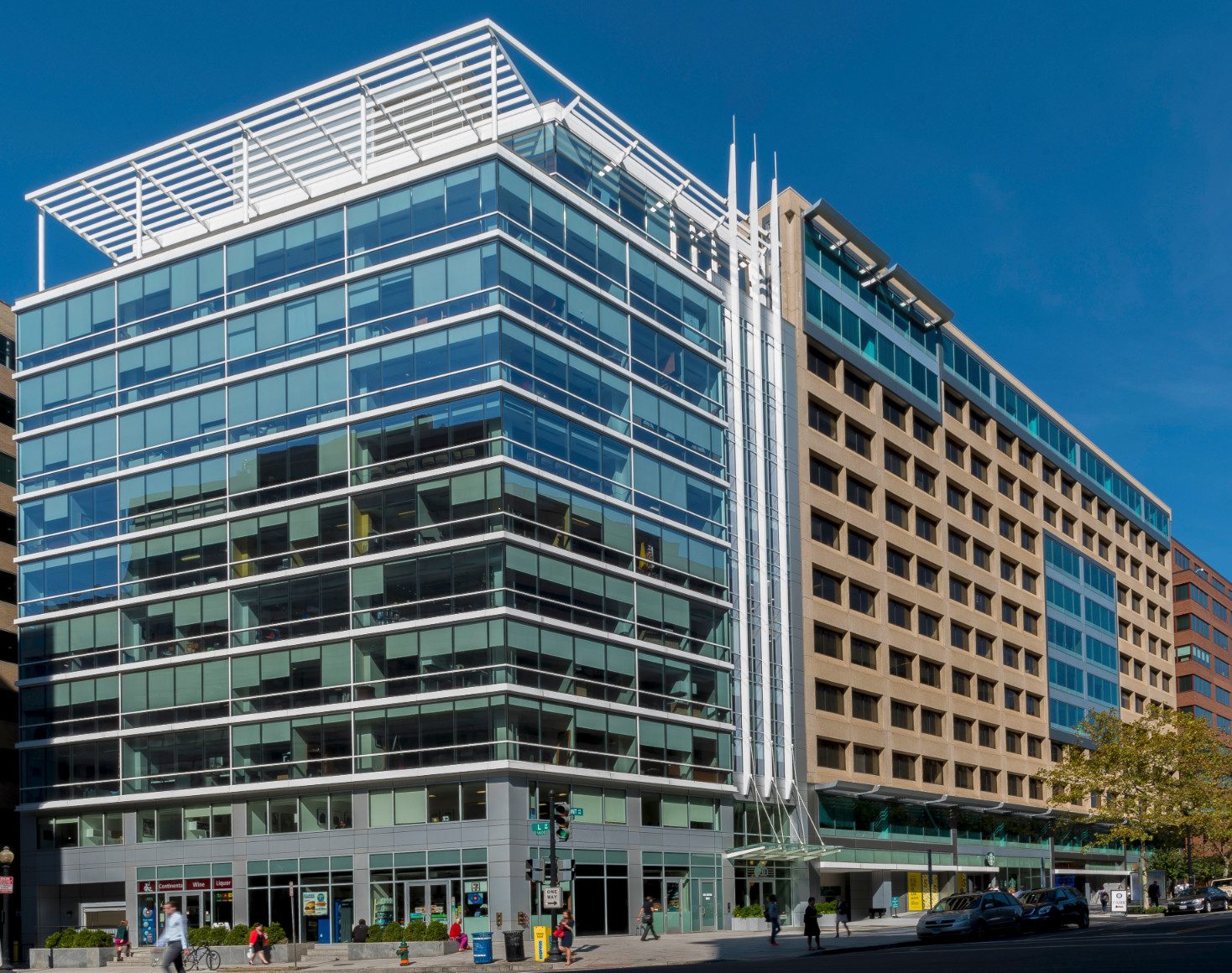 Modern glass office building on city street.