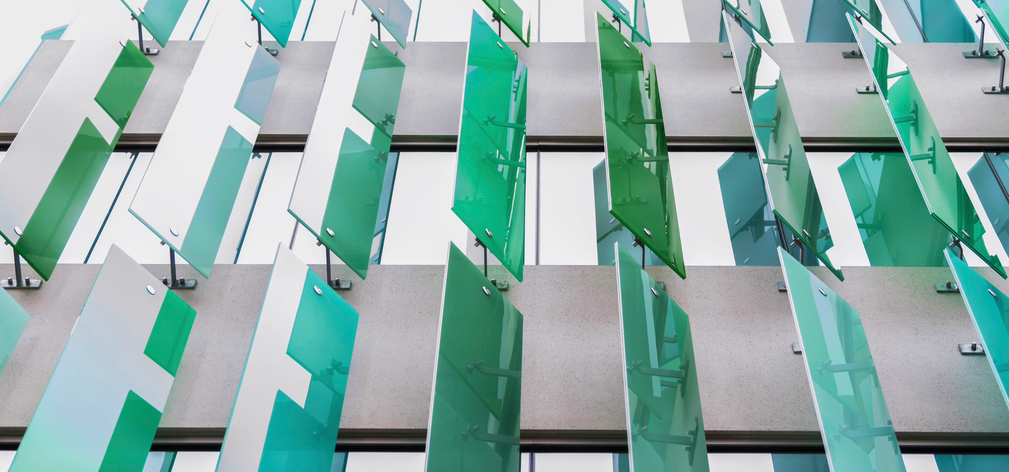 Abstract green glass panels on building facade.