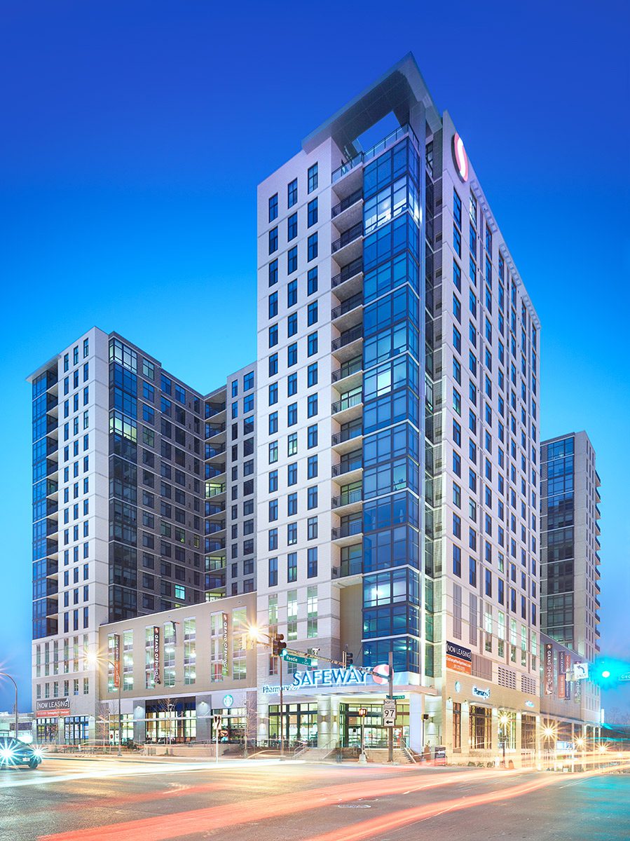 Modern urban building with illuminated storefronts.